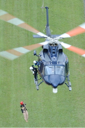 O helicóptero Bell 412 da DSP paira sobre um campo verde, enquanto os tripulantes içam soldados para dentro da aeronave. Foto Greg L. Davis www.focalplaneimagery.com 